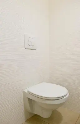 a bathroom with a white toilet in a white wall at Cozy studio in Old Town by URBAN RENT in Vilnius