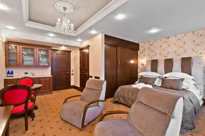 a bedroom with two beds and a table and chairs at Aqua Center Apartments in Druskininkai