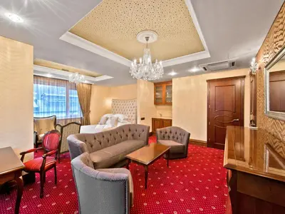 a hotel room with a couch and a table and chairs at Aqua Center Apartments in Druskininkai