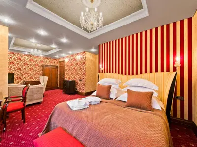 a hotel room with two beds and a chandelier at Aqua Center Apartments in Druskininkai
