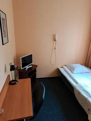 a hotel room with a bed and a desk with a computer at Jeruzale Hotel in Vilnius