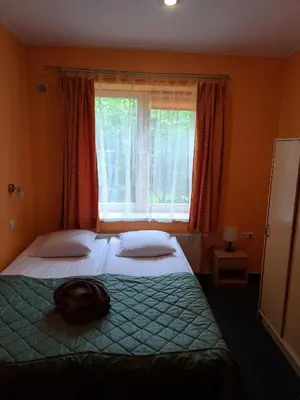 a bedroom with a bed and a window with red curtains at Jeruzale Hotel in Vilnius