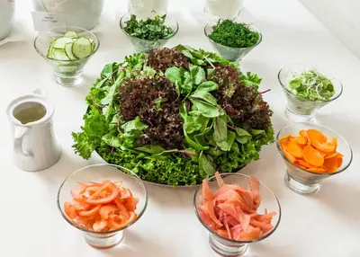 a table topped with a salad and bowls of vegetables at Royal SPA Residence in Birštonas