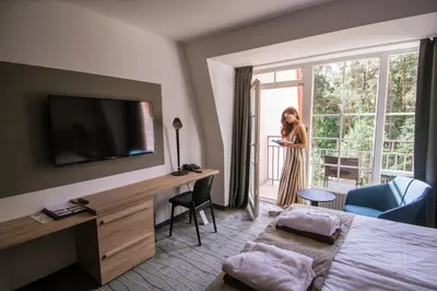 a woman standing in a hotel room with a window at Royal SPA Residence in Birštonas