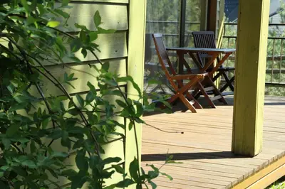 a deck with a chair and a table on a porch at Margis Hotel & SPA in Trakai