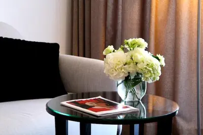 a table with a vase of flowers and a book at Margis Hotel & SPA in Trakai