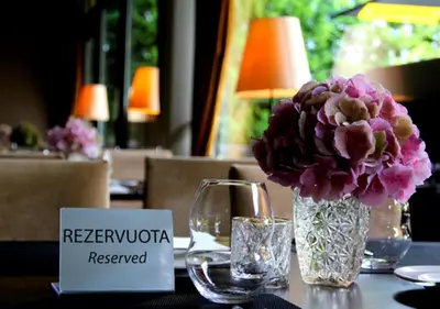 a table with a vase of flowers on a table at Margis Hotel & SPA in Trakai