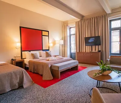 a hotel room with two beds and a flat screen tv at VICTORIA Hotel Kaunas in Kaunas