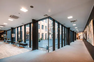 a corridor of a building with large glass windows at VICTORIA Hotel Kaunas in Kaunas