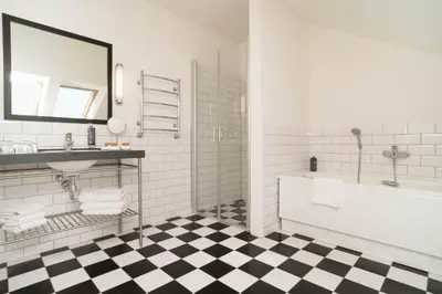 a bathroom with a black and white checkered floor at VICTORIA Hotel Kaunas in Kaunas