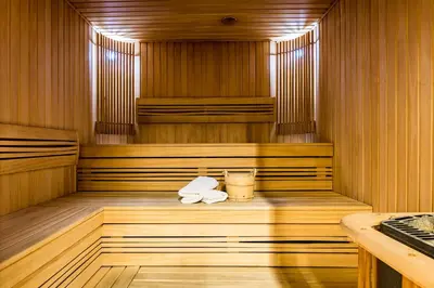 a sauna with two towels and a drink in it at VICTORIA Hotel Kaunas in Kaunas