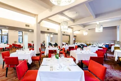 a dining room with white tables and red chairs at VICTORIA Hotel Kaunas in Kaunas