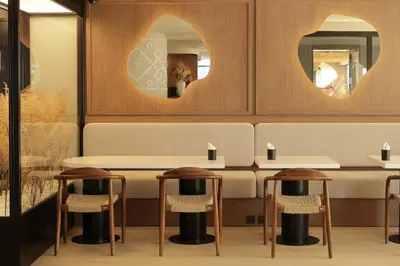 a dining room with a table and two stools at AIRINN Vilnius Airport Hotel RENOVATED 2025 in Vilnius