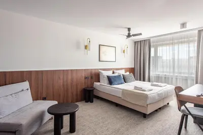 a hotel room with a bed and a couch at AIRINN Vilnius Airport Hotel RENOVATED 2025 in Vilnius