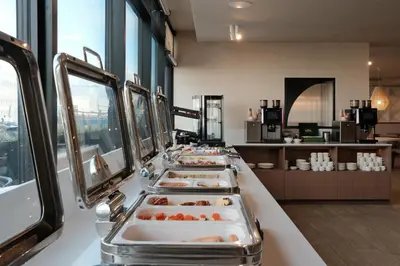 a buffet line with several trays of food on display at AIRINN Vilnius Airport Hotel RENOVATED 2025 in Vilnius