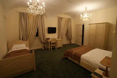 a hotel room with two beds and a desk at Bistrampolis Manor in Kučiai