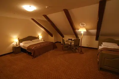 a hotel room with a bed and a table with a lamp at Bistrampolis Manor in Kučiai