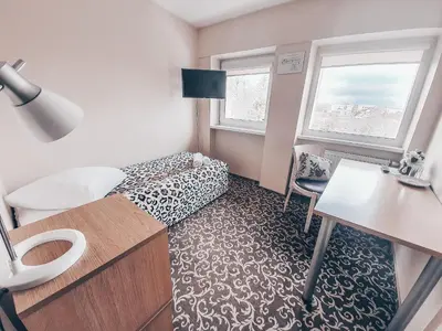 a small room with a bed and a desk and window at Pervaža in Panevėžys