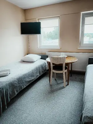 a bedroom with two beds and a table and a chair at Pervaža in Panevėžys