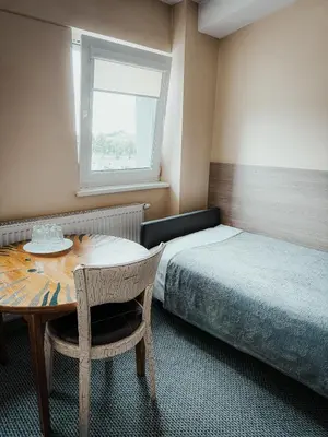 a room with a table and a bed and a window at Pervaža in Panevėžys