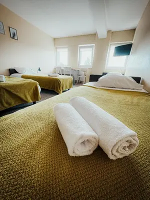 two beds in a room with towels on the floor at Pervaža in Panevėžys