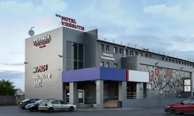 a building with cars parked in front of it at Pervaža in Panevėžys