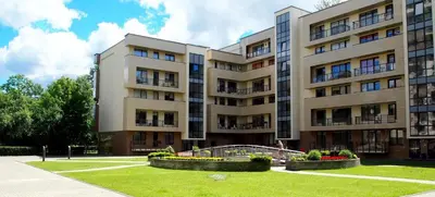 a large apartment building with a park in front of it at Central Druskininkai Apartment in Druskininkai