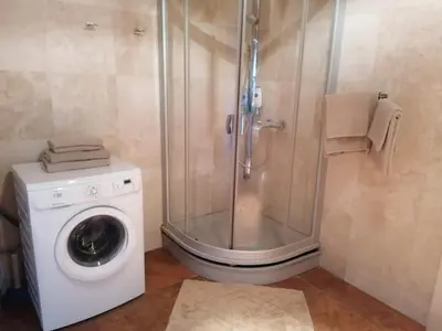 a bathroom with a shower and a washing machine at Central Druskininkai Apartment in Druskininkai