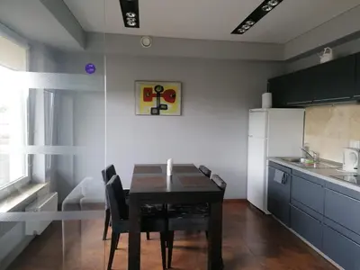 a kitchen with a table and chairs in a room at Central Druskininkai Apartment in Druskininkai