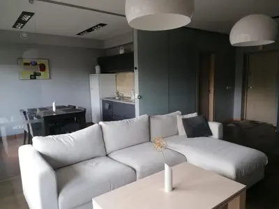 a living room with a white couch and a table at Central Druskininkai Apartment in Druskininkai