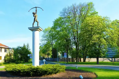 a statue of a man on a pedestal in a park at Central Apartments Karolina in Druskininkai