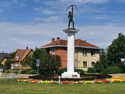a statue of a man on a pole in a park at Central Apartments Karolina in Druskininkai