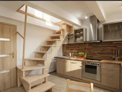 a kitchen with a wooden staircase in a room at Giedres Old town studio in Kaunas