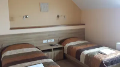 a hotel room with two beds and a table at Apartamentai 