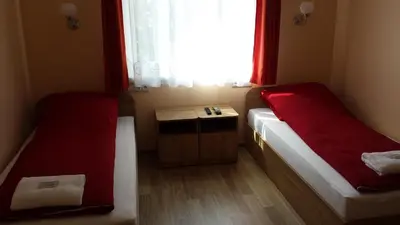 a small room with two beds and a window at Apartamentai 
