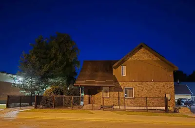 a brown brick house with a fence in front at Apartamentai 