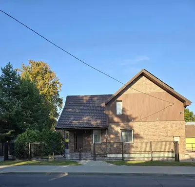 a brown brick house with a black fence at Apartamentai 