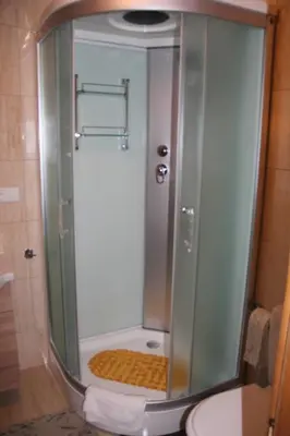 a glass shower in a bathroom with a toilet at Apartamentai 