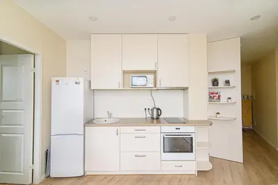 a kitchen with white cabinets and a refrigerator at Sky Studio near the Vilnius Center in Vilnius