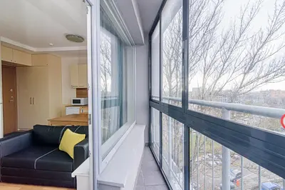 a living room with a couch and a large window at Sky Studio near the Vilnius Center in Vilnius