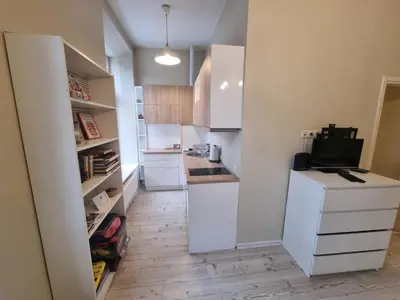 a kitchen with white cabinets and a white refrigerator at Igo apartment Uzupis in Vilnius