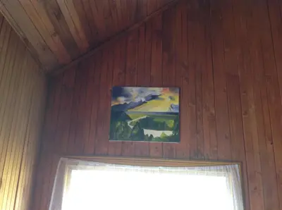 a painting hanging above a door in a wooden room at 