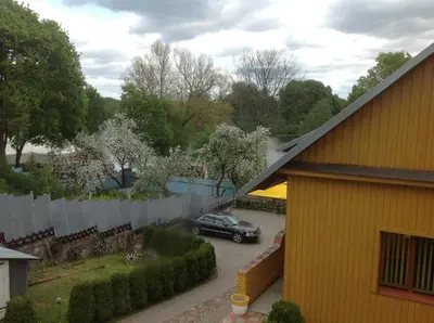 a car parked in a parking lot next to a yellow house at 