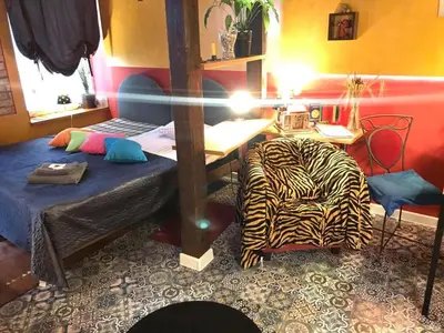 a room with a bed and a desk and a chair at Prie Miesto Vartų in Vilnius