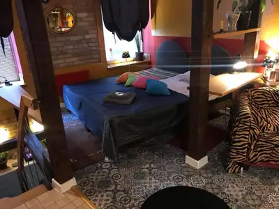 a room with a bed and a table in it at Prie Miesto Vartų in Vilnius