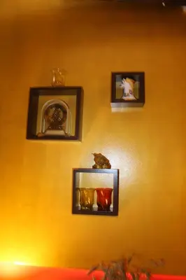 a wall with four pictures on a yellow wall at Prie Miesto Vartų in Vilnius