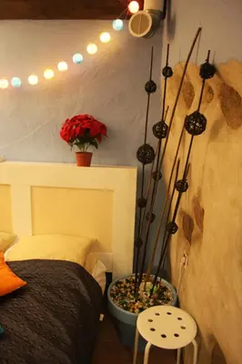 a bedroom with a bed and a plant in a pot at Prie Miesto Vartų in Vilnius
