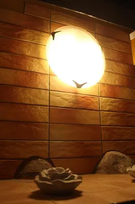 a light on a wall with two chairs at a table at Prie Miesto Vartų in Vilnius