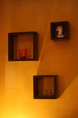 a wall with two shelves with vases on it at Prie Miesto Vartų in Vilnius