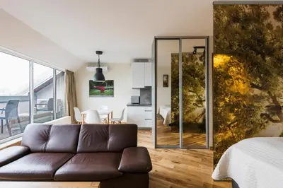 a living room with a couch and a bedroom at Napoleon Hill Apartment in Kaunas
